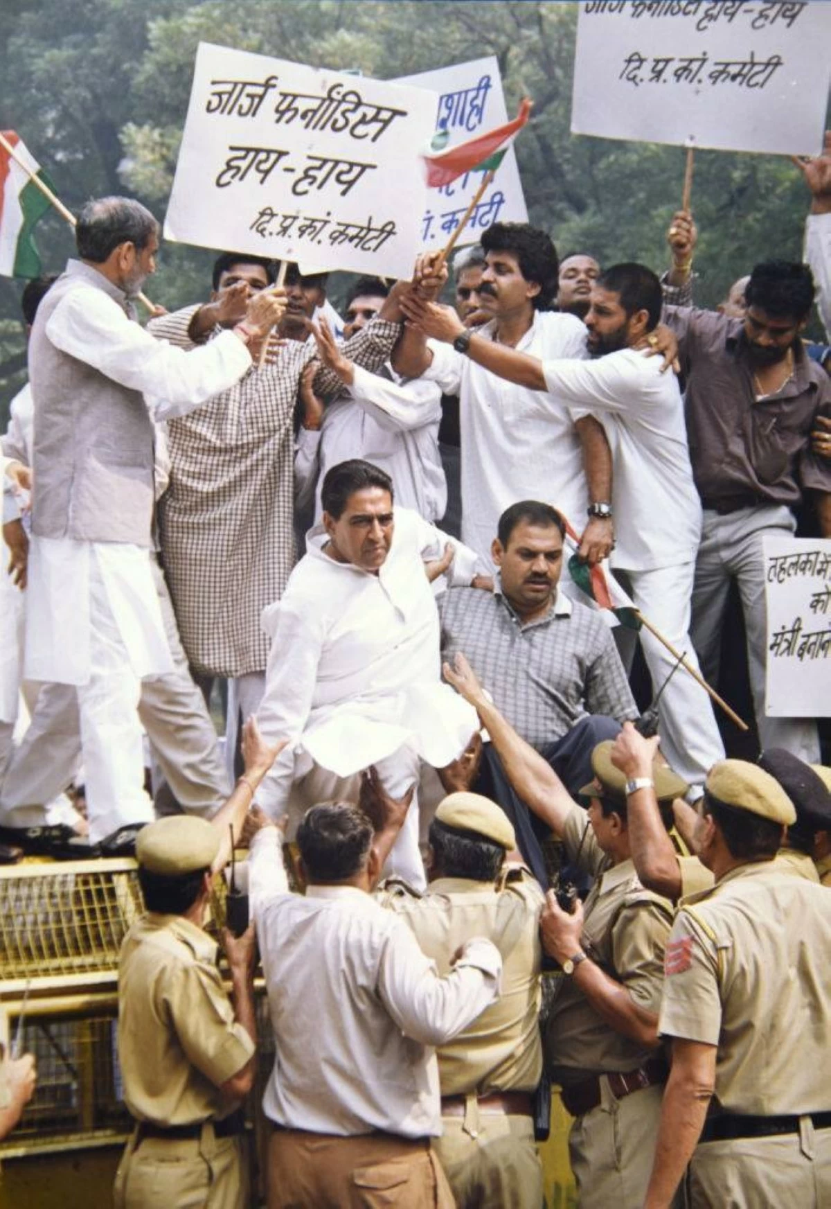Congress leaders Ambika Soni, Sajjan Kumar, Anand Sharma and others climb a barricade to break the police cordon outside the residence of Defence Minister George Fernandes in New Delhi on August 08, 2003. (Photo by Sondeep Shankar/Getty Images)