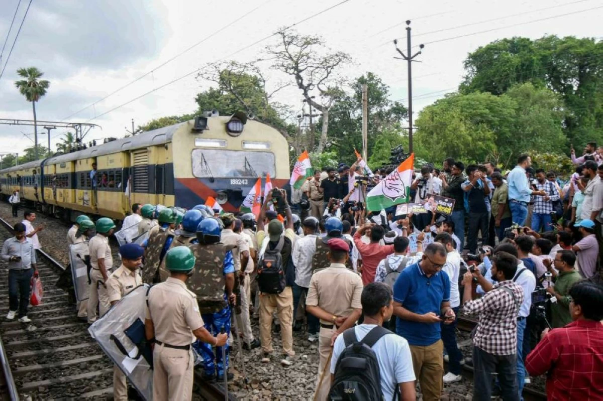 Security personnel stand guard as agitators stop a train during a protest amid 'Bihar bandh' called by the INDIA bloc against Special Intensive Revision in the state, at Sachiwalay Halt Railway station in Patna. Over 25 crore workers wee mobilised. (Credit: PTI)