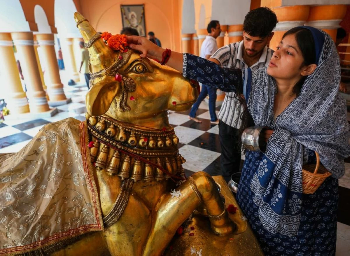 Woman offers prayers to 'Nandi' after worshiping Lord Shiva at Ranbireshwar temple in Jammu