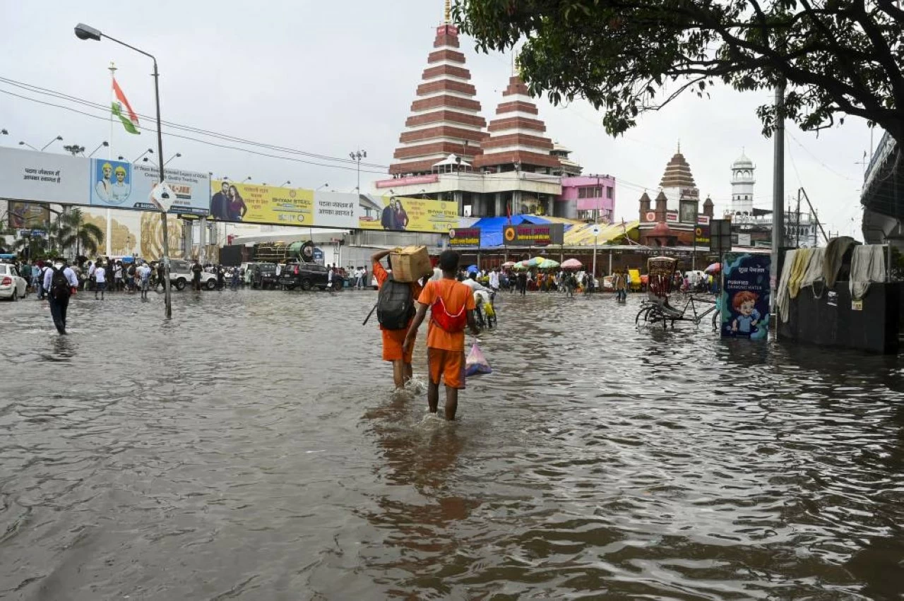 'Kanwariyas' wade through a waterlogged road following heavy rainfall in Patna (Credit: PTI)
