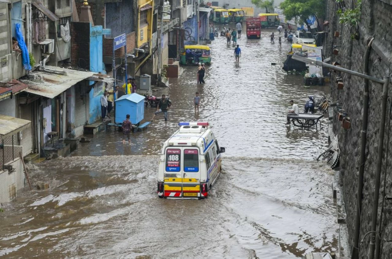 An ambulance moves through a waterlogged road after rain, in Ahmedabad (Credit: PTI)
