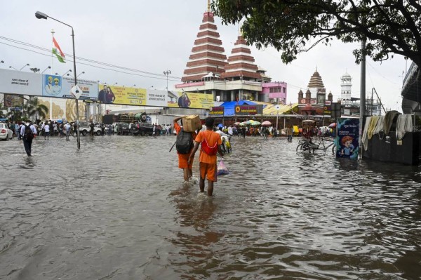 'Kanwariyas' wade through a waterlogged road following heavy rainfall in Patna (Credit: PTI)