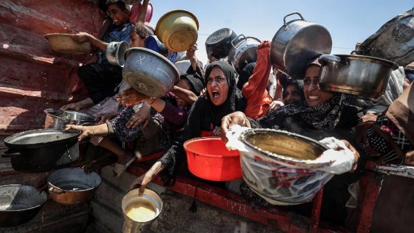 A charity distributes meals to Palestinians facing food shortages amid ongoing Israeli attacks and severe restrictions in Gaza City, Gaza. (Photo by Ali Jadallah/Anadolu via Getty Images)