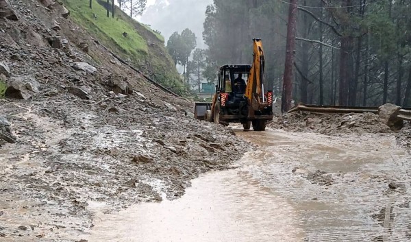  An excavator being used to clear debris from a road following a landslide, in Uttarkashi 