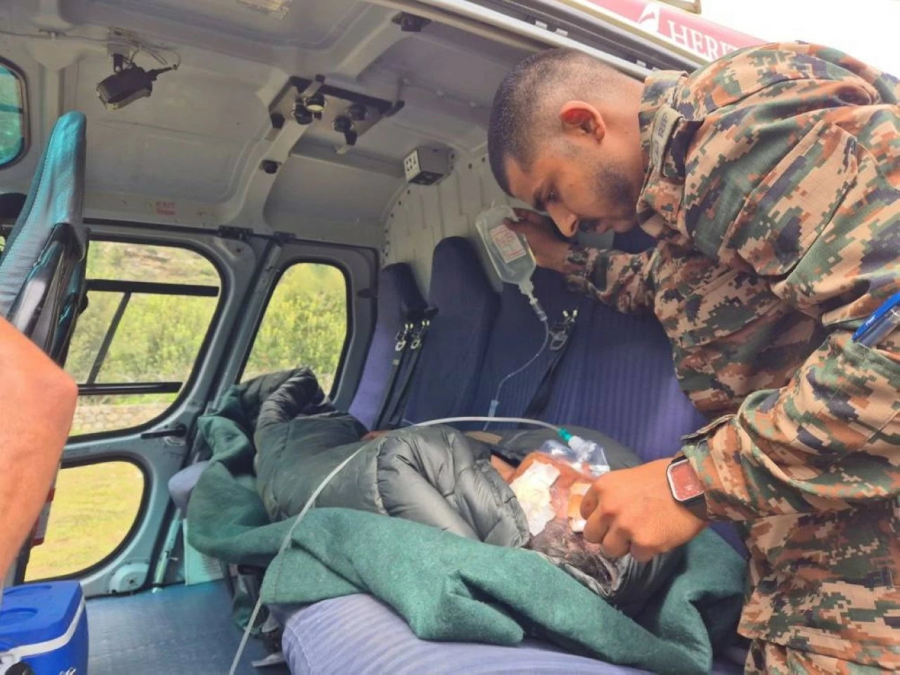 A soldier provides medical aid to a rescued victim inside an air ambulance. Critical patients were airlifted to Harsil helipad for immediate treatment.