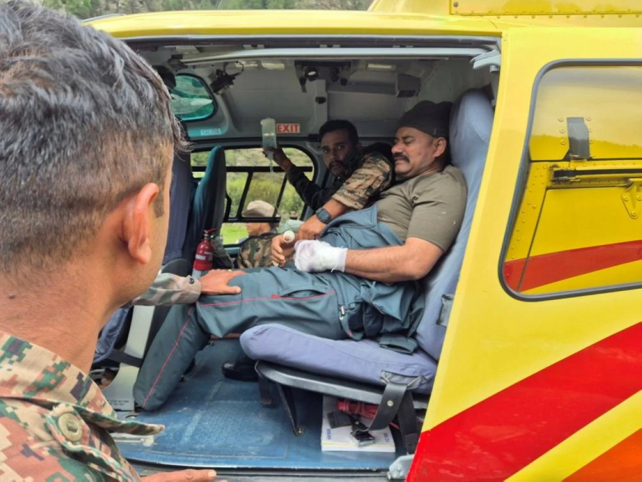 An injured soldier is being airlifted by emergency personnel on a rescue helicopter. 11 army personnel were rescued from the worst-hit Dharali area.