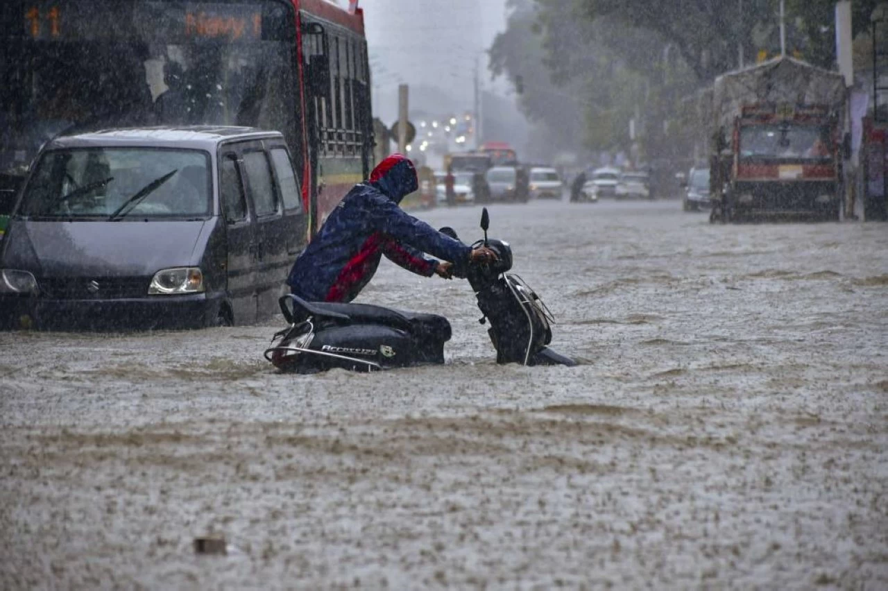A commuter stuck in flooded road in Hindamata area of Mumbai on Monday. (PTI) 