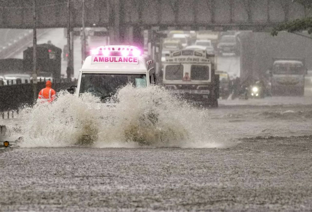 An ambulance try to wade through a waterlogged road at Kurla in Mumbai on Monday. (PTI)