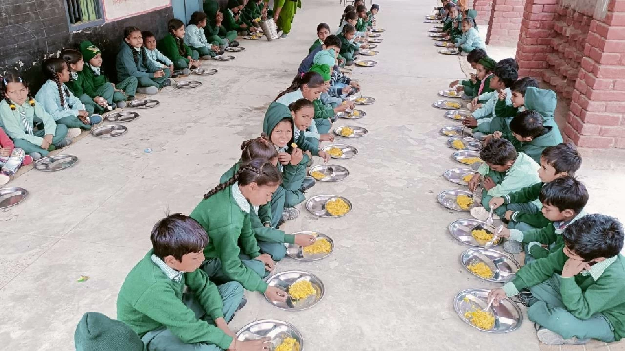 Children eat a midday meal at a government school.