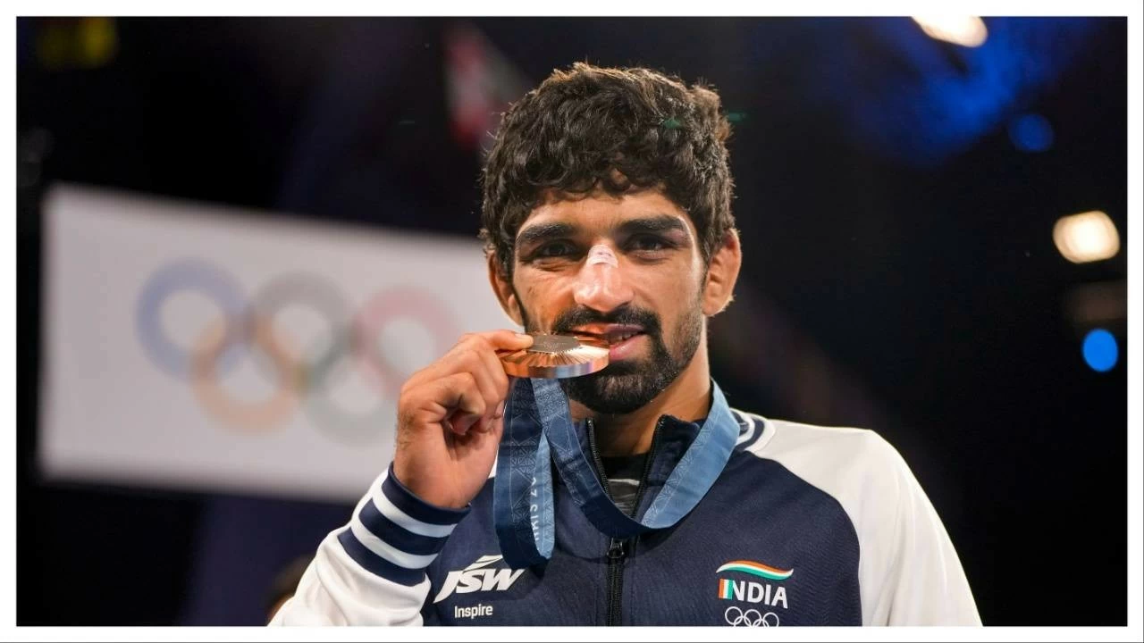 Aman Sehrawat poses for photos at the podium during for the 57kg free-style wrestling event at the Paris.