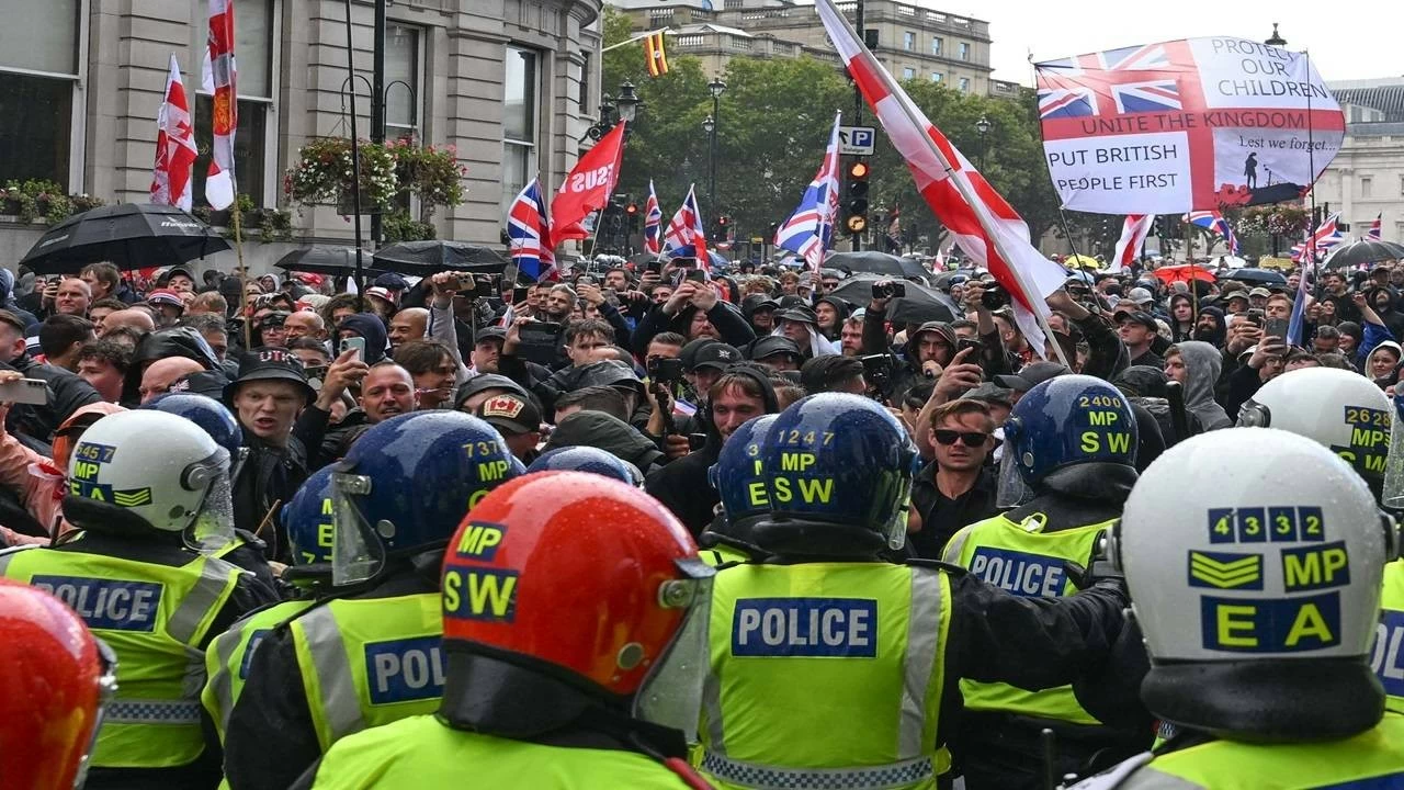 Clashes erupt between police and protesters as thousands of people march through central London in a rally called "Unite the Kingdom." (Photo by Rasid Necati Aslim/Anadolu via Getty Images)