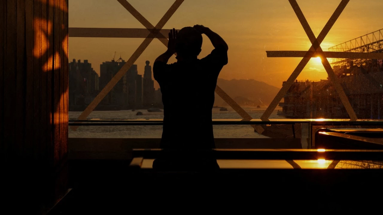 A shop worker is taping a glass window in preparation for Typhoon Ragasa at a store in Hong Kong