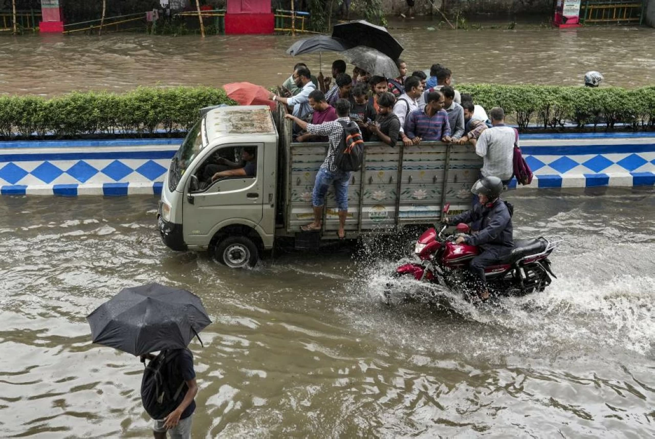  Commuters get on a vehicle to move through a waterlogged road amid rainfall