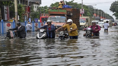 People make their way through a flooded road after heavy rainfall, in Kolkata, on Tuesday, Sept. 23, 2025. (PTI Photo)