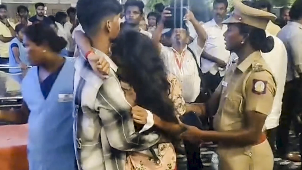 A police official consoles an injured after a stampede-like situation occurred during a rally presided over by TVK chief and actor Vijay, in Karur district, Tamil Nadu