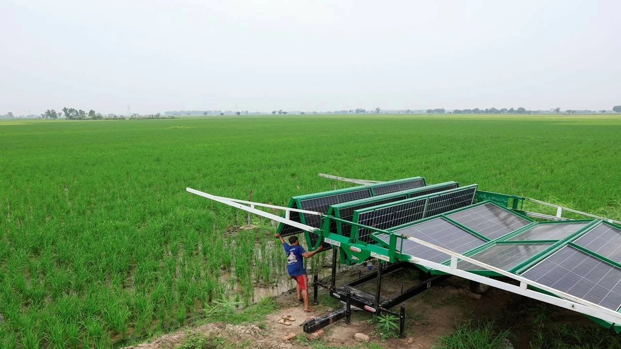 A worker installs a folding solar panel unit, to run a tube well, the motorised pump that taps groundwater, in a rice field in Muridke, Sheikhupura District in Punjab province, Pakistan August 12, 2025. (REUTERS/Akhtar Soomro)