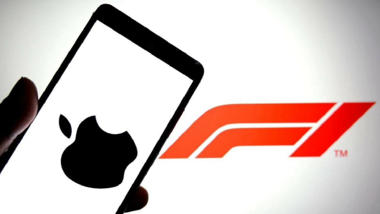 In this photo illustration, an Apple logo is seen displayed on a smartphone with a Formula 1 (F1) logo in the background. 