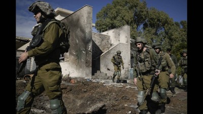 Israeli soldiers inspect the site where a rocket fired from Lebanon landed in a backyard in Kiryat Shmona, northern Israel.