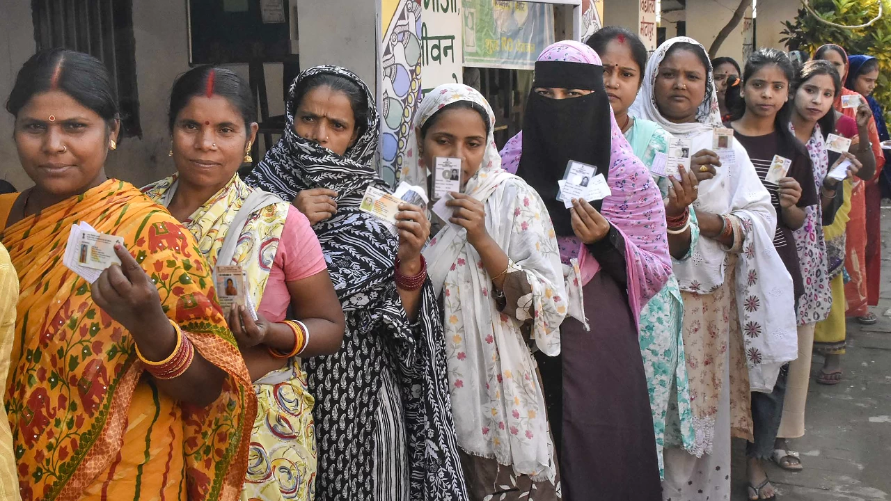 Voters wait in a queue to cast votes at a polling station in Patna. Women voters are expected to play a key role in this Assembly election with both NDA and the INDIA alliance reaching out to them. (Photo credit: PTI)