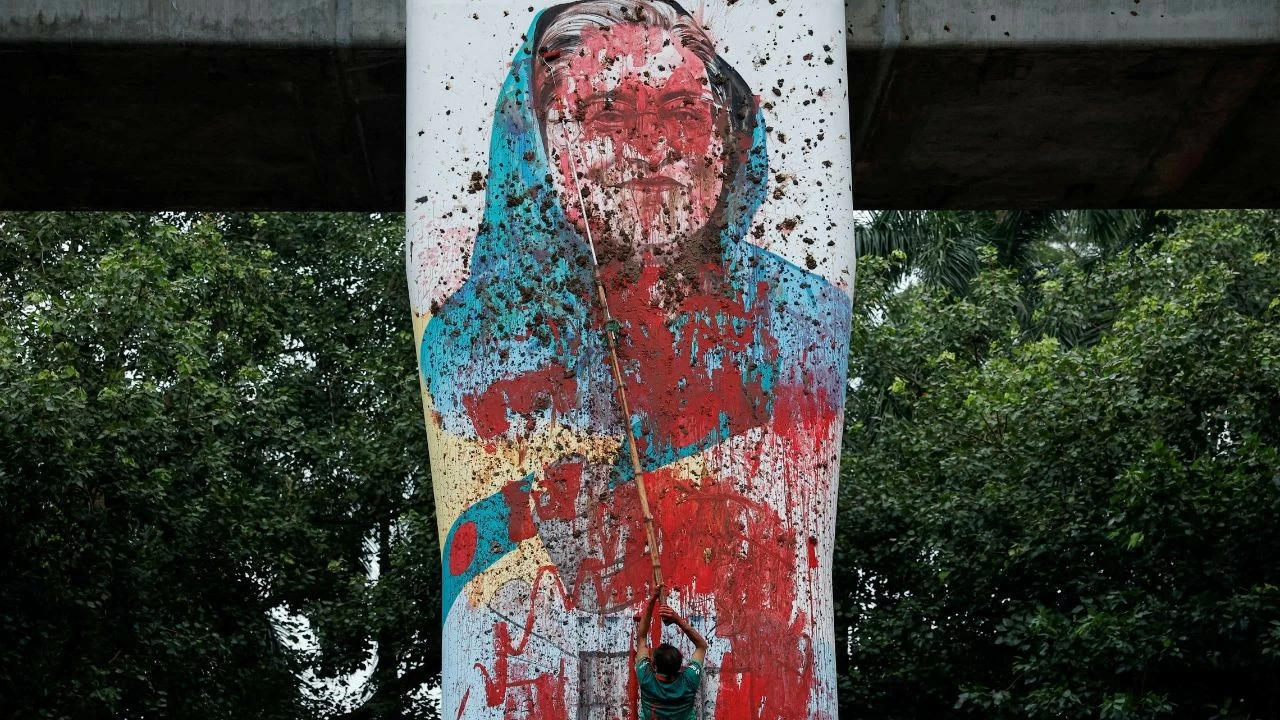 A protester vandalises a mural of Bangladeshi Prime Minister Sheikh Hasina with paint, demanding her resignation at Teacher Student Center (TSC) area of University of Dhaka in Dhaka, August 3, 2024. 