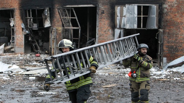 Firefighters carry a ladder during a response effort to a large-scale overnight Russian drone attack in Dnipro, Ukraine, on November 18, 2025. (Photo: Getty Images)
