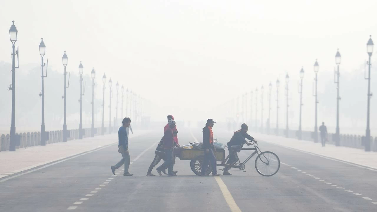  Workers push a cart across Kartavya Path during a smoggy winter morning, in New Delhi, Saturday, Nov. 22, 2025