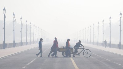  Workers push a cart across Kartavya Path during a smoggy winter morning, in New Delhi, Saturday, Nov. 22, 2025