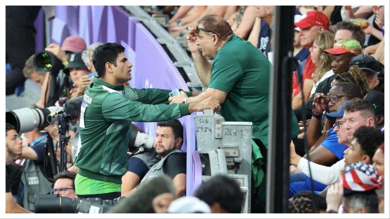 Arshad Nadeem speaks with his head coach during Paris Olympics on August 8, 2024.