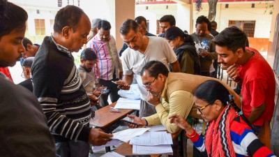 Booth Level Officers check and collect enumeration forms as voters arrive to submit them for the special intensive revision (SIR) of electoral rolls. (Representative image: PTI)