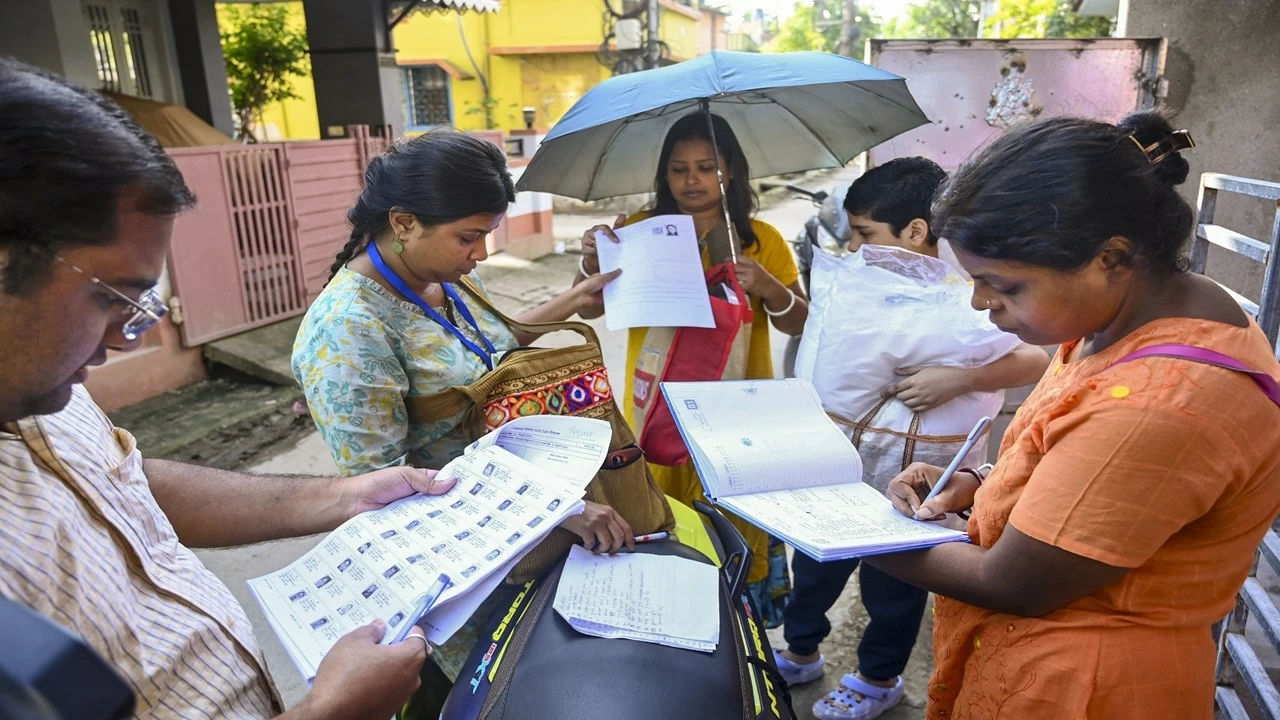 Booth Level Officers on field distribute enumeration forms to voters as part of the Special Intensive Revision (SIR) of election rolls exercise. (Photo PTI)