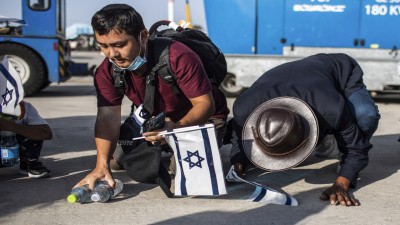 New Jewish emigrants from the Bnei Menashe (sons of Manasseh) community in India, kneel to the ground as they cheer after arriving at Ben Gurion Airport near Tel-aviv.