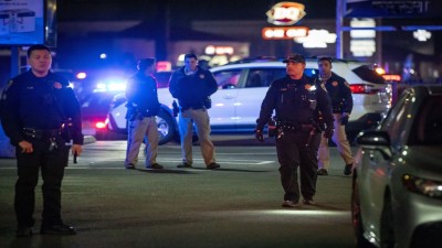 First responders walk through a parking lot near the scene of a mass shooting in Stockton.