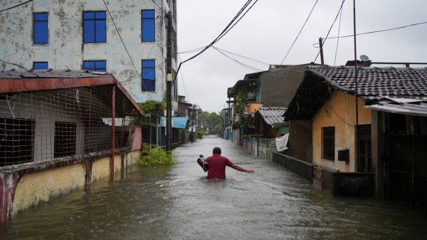 A man wades through a flooded street following heavy rainfall in Wellampitiya, Sri Lanka, November 28, 2025.