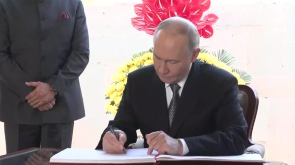 Putin_signs_visitors_book_at_Raj_Ghat