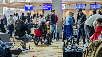Passengers wait at the counters at the IGI Airport in New Delhi on Friday.