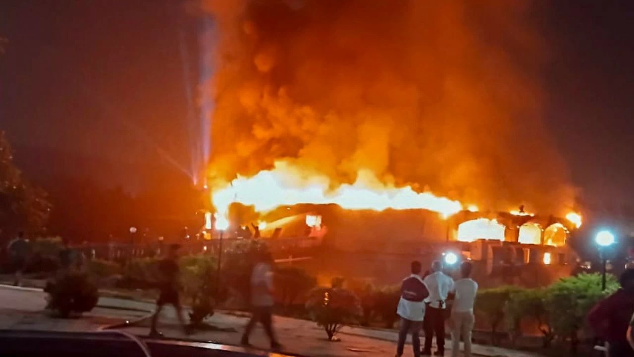 The video shows a performer dancing on stage when flames suddenly appear inside the crowded venue.