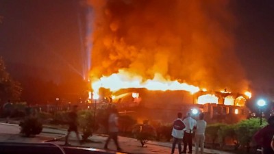 The video shows a performer dancing on stage when flames suddenly appear inside the crowded venue.