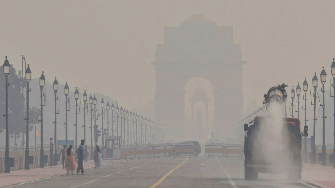 An anti-smog gun sprays water droplets to curb air pollution, with India Gate visible in the backdrop, as air quality deteriorates in Delhi-NCR