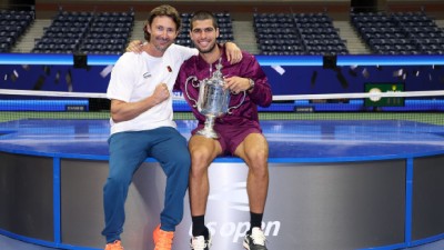 Carlos Alcaraz of Spain poses with his trophy next to his coach Juan Carlos Ferrero after defeating Jannik Sinner in US Open 2025 final in New York. 