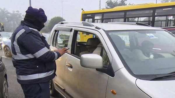 A police official checks documents of a vehicle stopped at the Delhi-Noida Chilla Border, in New Delhi. (Photo: PTI) 