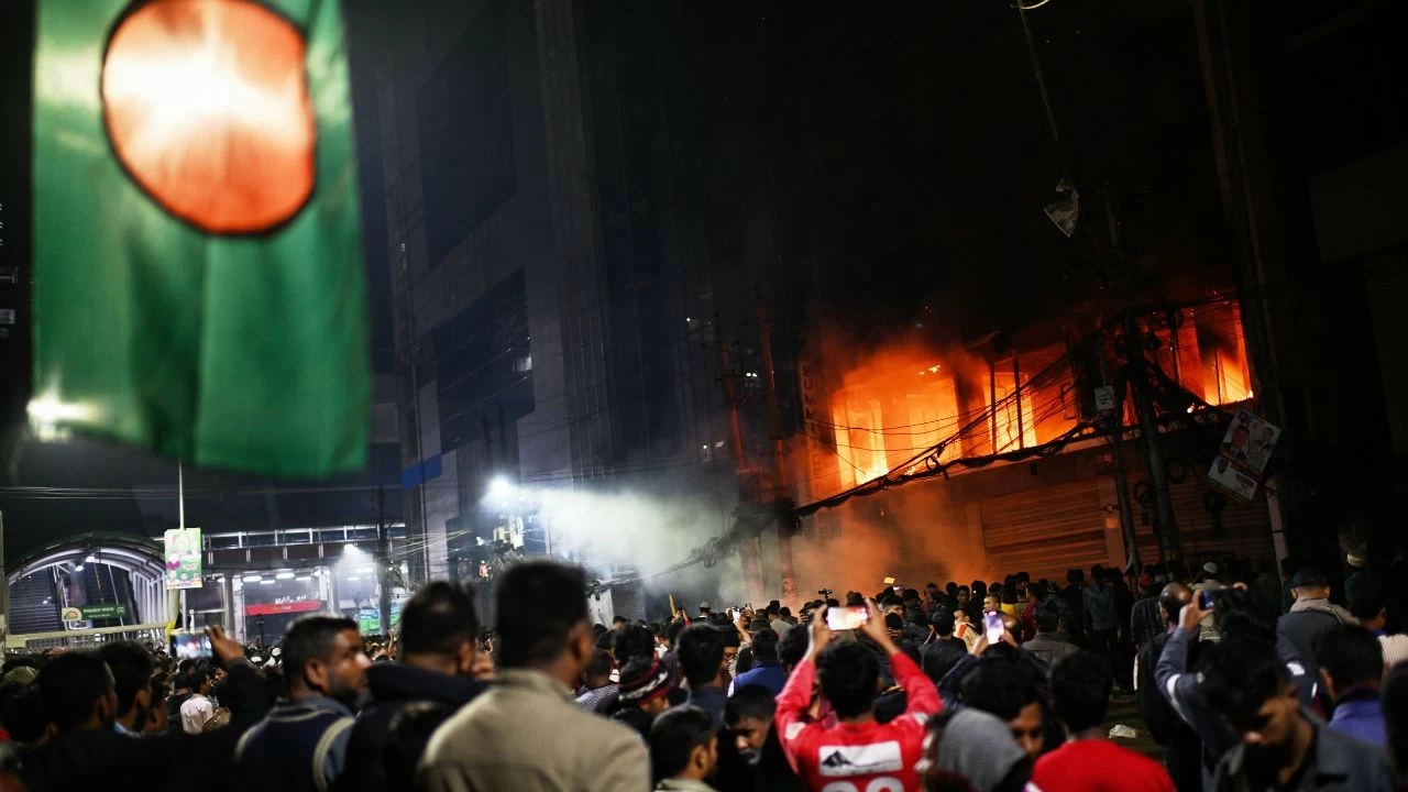 A crowd gathers near the premises of the Prothom Alo daily newspaper which was set on fire by angry protesters after news reached the country from Singapore of the death of a prominent activist Sharif Osman Hadi 