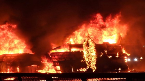 Flames and smoke billow out after a bus caught fire following a collision with a speeding truck, in Chitradurga, early Thursday, Dec. 25, 2025. (Photo PTI)