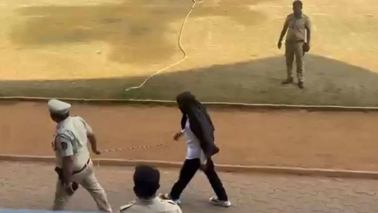 Pune gangster Bandu Andekar with his face covered accompanied by police officers walks to file his nomination papers for the civic polls