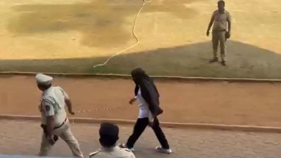 Pune gangster Bandu Andekar with his face covered accompanied by police officers walks to file his nomination papers for the civic polls