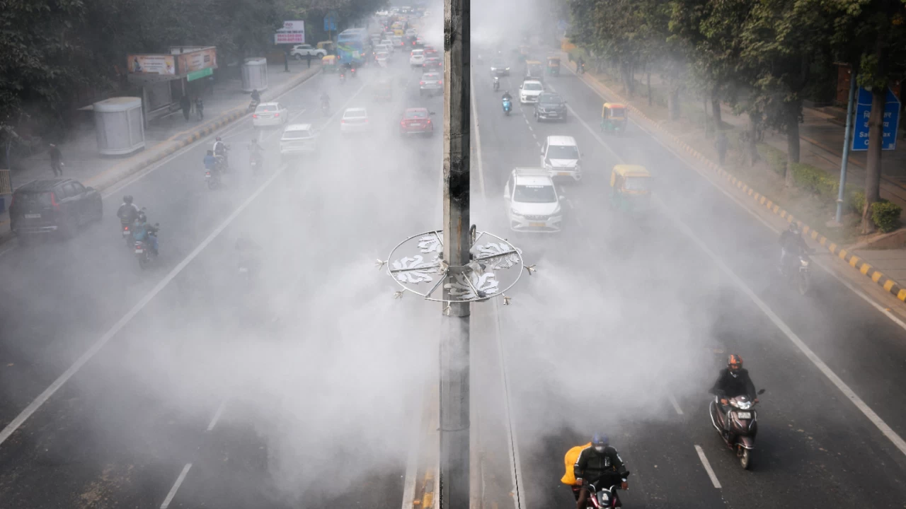 Vehicles drive past anti-smog misting system installed on a road to control air pollution in New Delhi. (Photo credit: Reuters)
