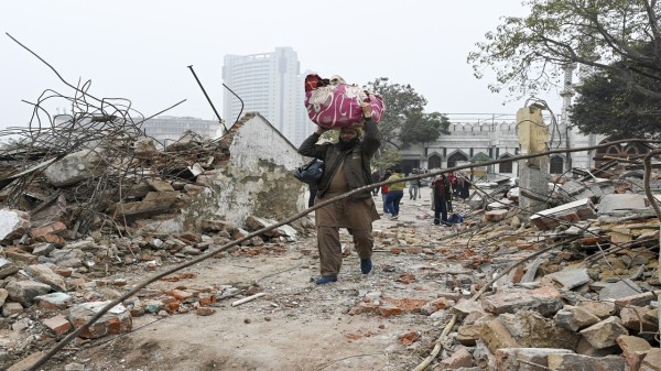 A man moves through debris after an anti-encroachment drive near the Syed Faiz Elahi Mosque, in New Delhi, Wednesday, Jan. 7, 2026. (PTI Photo)
