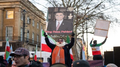 A protester holds a portrait of Mohammad Reza Pahlavi during a demonstration outside Downing Street in London. (Photo by Andrea Domeniconi/SOPA Images/LightRocket via Getty Images)