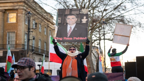 A protester holds a portrait of Mohammad Reza Pahlavi during a demonstration outside Downing Street in London. (Photo by Andrea Domeniconi/SOPA Images/LightRocket via Getty Images)