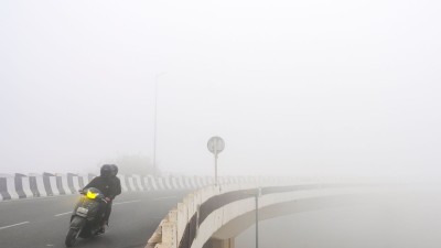  Commuters make their way through dense fog during a cold winter morning, in New Delhi on January 17, 2026 
