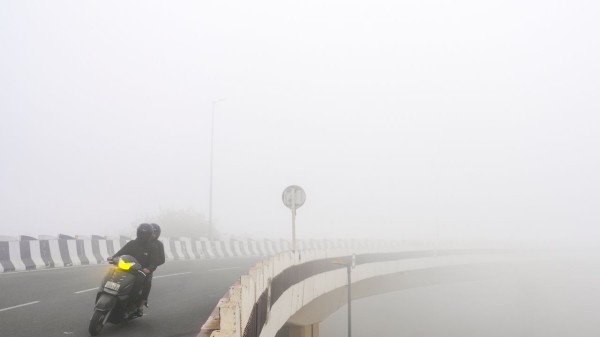  Commuters make their way through dense fog during a cold winter morning, in New Delhi on January 17, 2026 